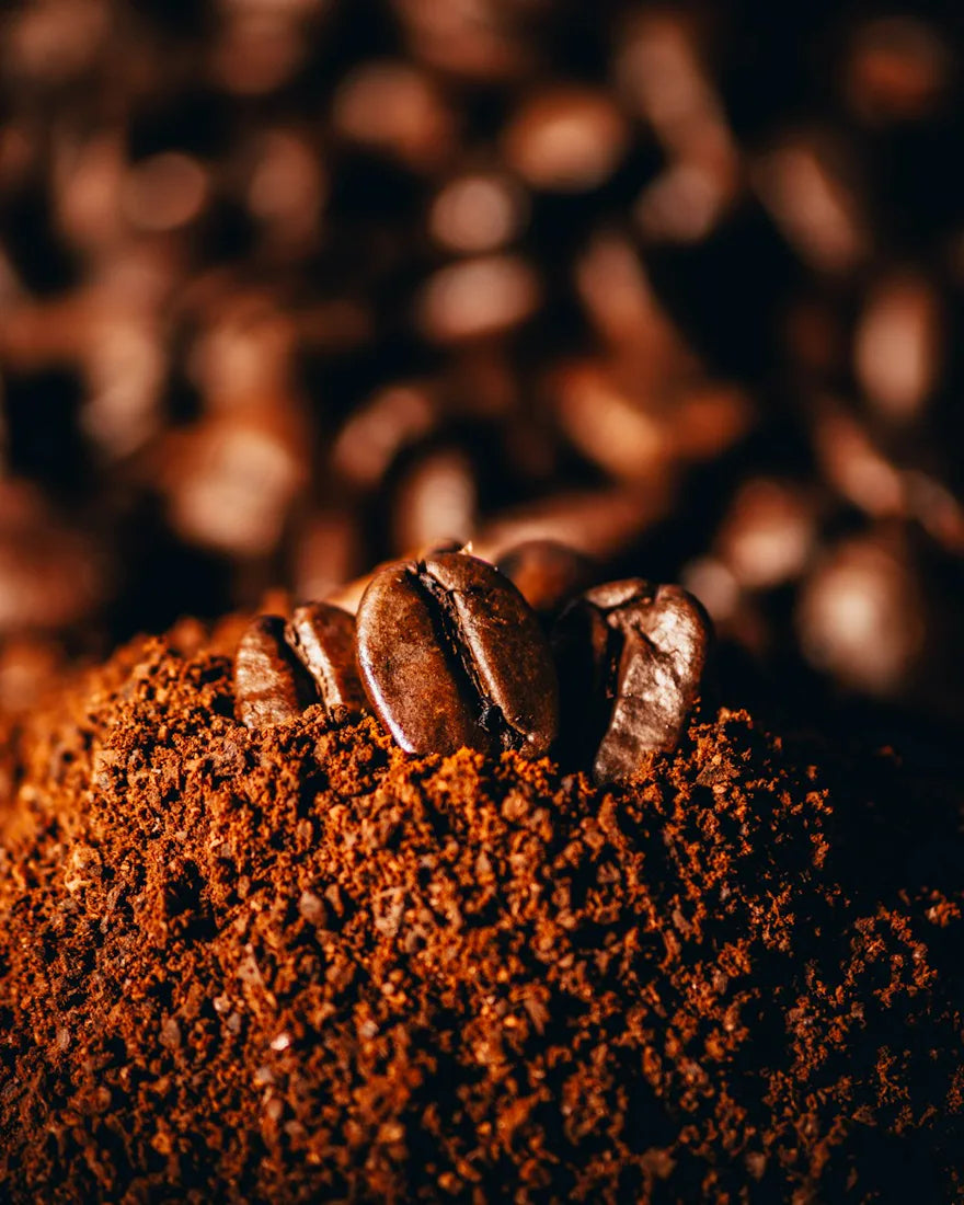Koffiebonen op een berg vers gemalen koffie